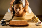 Frau erhält eine traditionelle Thai-Massage zur Dehnung und Entspannung auf einer Bodenmatte