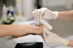 Fachgerechte Pediküre mit Nagelfeile im Kosmetikstudio durch eine Person mit Handschuhen