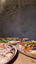 Frisch gebackene Pizza-Variationen mit knusprigem Rand, belegt mit Rucola, Gemüse und cremigem Käse bei Zampano To Go Frankfurt
