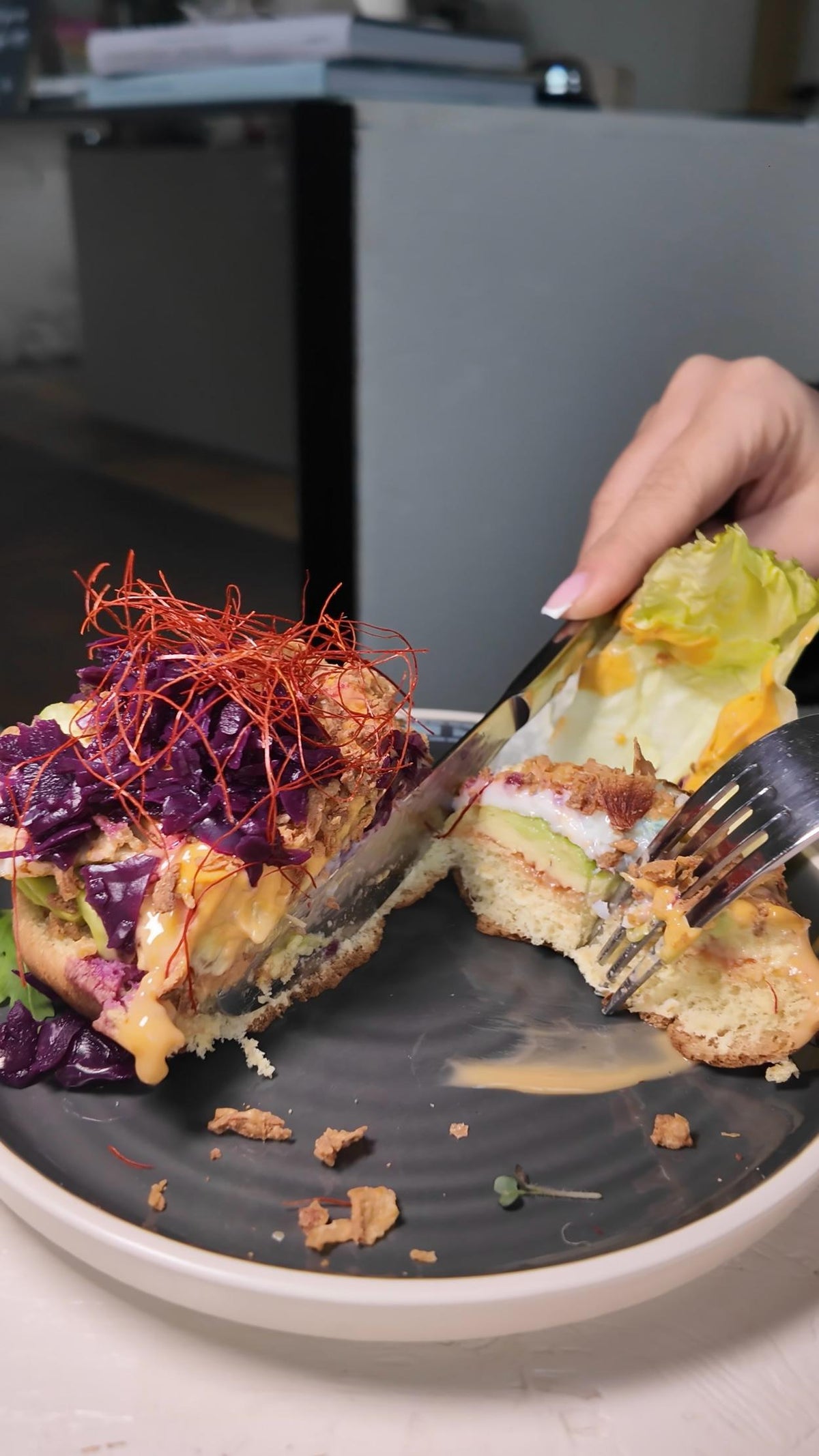 Ein Burger bei LALA Smashburger Frankfurt wird mit Messer und Gabel angeschnitten