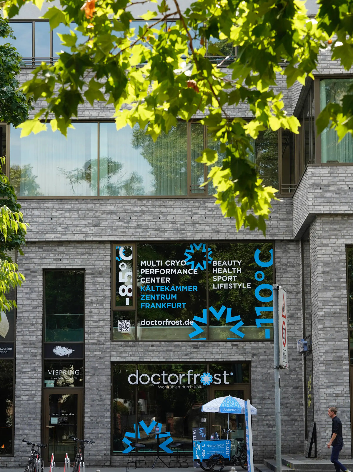 ußenfassade von Doctorfrost Frankfurt mit großen Fenstern, Werbeaufschrift für Kryotherapie, Figurformung und Beauty Treatments bei –110 °C