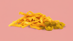 Loaded Fries mit cremiger Käsesauce und Jalapeños auf rosa Hintergrund als herzhaftes Gericht bei The Burgerz in Oberhausen.