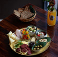 Orientalischer Frühstücksteller mit Käse, Wurst, Eiern, Oliven, Dips, frischem Obst und Brotkorb, dazu ein Glas Orangensaft in der Shima Café Bar Frankfurt