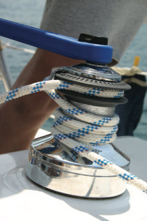 Nahaufnahme einer Segelwinch mit blau-weißem Tauwerk auf einer Segelyacht des Adriatic Sailing Team Dortmund, im Hintergrund das Meer
