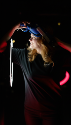 Frau setzt eine VR Brille bei einem Escape Game im VAONS VR Event Center in München auf