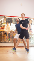 Zwei Männer spielen gemeinsam Squash auf einem Court in der Sportinsel Taufkirchen