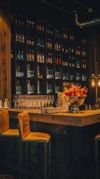 Stilvolle Bar bei The ASH Essen – eleganter Barbereich mit Getränkeregalen, Barhockern und modernem Restaurantambiente