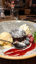 Lava Cake bei The ASH Essen – warmes Schokoküchlein mit flüssigem Kern, Vanilleeis, Beeren und fruchtiger Sauce als Dessert