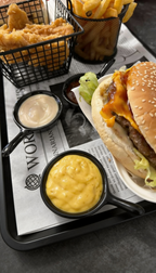Cheeseburger bei Burger Bites Corner Essen – saftiger Burger mit geschmolzenem Käse, frischem Salat und cremigen Dips als Beilage