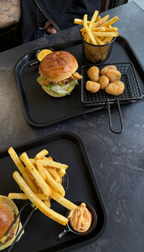 Burger Menü bei Burger Bites Corner Essen – Burger mit Pommes und knusprigen Snacks auf Tabletts angerichtet für einen herzhaften Genuss
