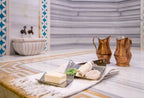 Hamam-Set mit Seife, Peelinghandschuh, Kupferkannen und Tüchern im stilvollen Marmorraum des Argan Garden Hamam Düsseldorf