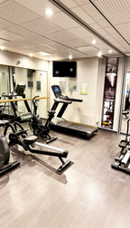 Fitnessbereich im Alma Spa Frankfurt – moderner Trainingsraum mit Laufband, Ergometer und Kraftgeräten für aktives Wellness und Fitnesstraining
