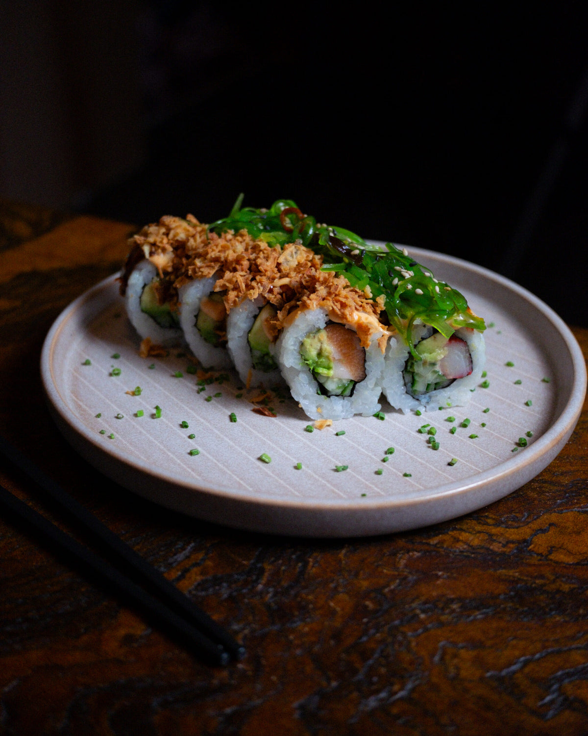 Sushi Rolle mit Lachs bei DUI Sushi Bochum – frisch zubereitete Sushi Spezialität mit Toppings, Sauce und Schnittlauch