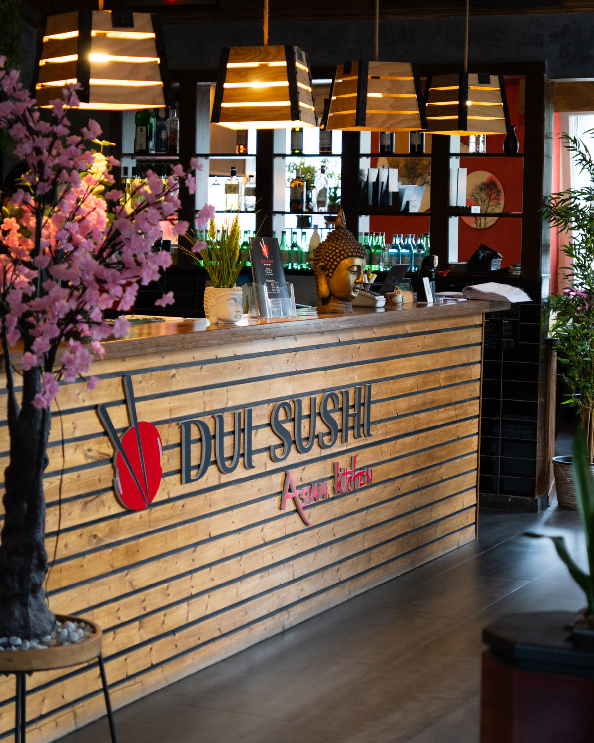 Modernes Restaurantambiente bei DUI Sushi Essen – stilvoller Empfangsbereich mit Theke, Beleuchtung und asiatischem Flair