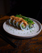 Sushi Rolle mit Lachs bei DUI Sushi Essen – frisch zubereitete Sushi Spezialität mit Toppings, Sauce und Schnittlauch