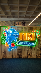 Leuchtendes Tiki Kinderland Logo in Solingen – farbenfrohes Neon Schild im tropischen Freizeitpark Design