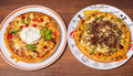 Zwei frisch zubereitete Pizzen bei Prados Il Siciliano Dortmund – Pizza Auswahl mit verschiedenen Belägen, serviert auf Tellern und zur Abholung erhältlich