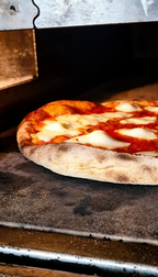 Frische Pizza bei Pizzeria Rusticale Dortmund, die im heißen Steinofen knusprig gebacken wird und mit geschmolzenem Käse belegt ist