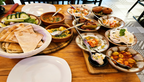 Orientalische Mezze Auswahl bei Al Moudyaf in Wuppertal mit Fladenbrot, verschiedenen Dips, Salaten und kleinen Vorspeisen auf einem gedeckten Tisch