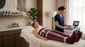Lymphdrainage Behandlung bei Dream Body Lounge, bei der eine Kundin entspannt auf einer Behandlungsliege liegt und eine Druckwellenmanschette zur Anwendung genutzt wird