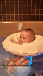 Baby Floating bei Maela Baby Spa Düsseldorf, bei dem ein Baby entspannt mit speziellem Schwimmkissen im warmen Wasser liegt