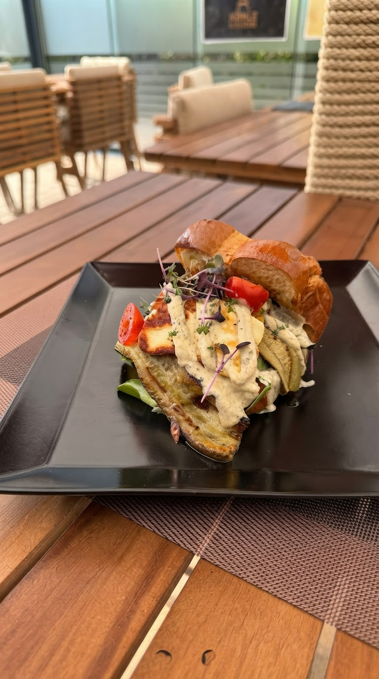 Brioche Sandwich bei Coal and Bean in Essen mit cremigem Belag, frischem Salat und herzhaften Zutaten auf einem schwarzen Teller serviert