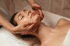 Frau liegt entspannt auf einer Behandlungsliege und erhält eine sanfte Gesichtsmassage