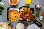 Indisches Gericht im Sweet Laddu Köln mit Tandoori Chicken, Butter Chicken, Reis, Naan, Chutney und Mango Lassi