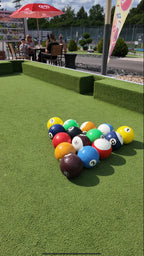 Bunte Bälle in Dreiecksformation auf einem großen Outdoor-Soccer-Billard-Feld mit Kunstrasen