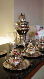 Türkischer Tee im Orientalischen Hamam Wuppertal mit traditionellem Teeservice, silberner Teekanne und kleinen Gläsern im Ruhebereich