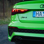 Rückansicht eines neon-grünen Audi RS3 mit sportlicher Heckschürze, LED-Rückleuchten und deutschem Kennzeichen