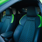 Nahaufnahme des Innenraums eines Audi RS3 mit schwarzen Sportsitzen und auffälligen grünen Akzenten