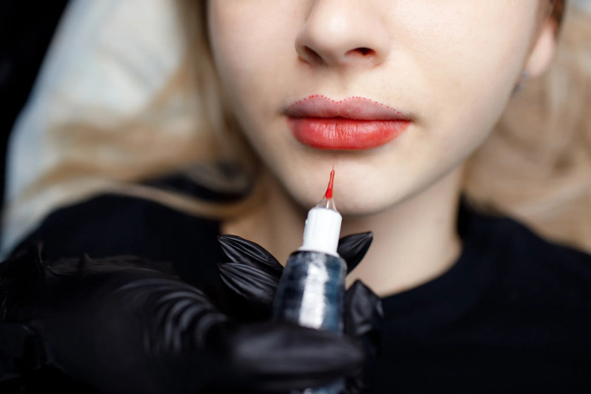 Nahaufnahme einer Frau während einer Lippenpigmentierung mit Permanent Make-up, die Farbe wird präzise aufgetragen