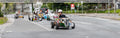 Teilnehmer einer Hotrod-Tour fährt im Mini-Fahrzeug mit Helm durch die Innenstadt von Aachen