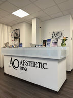 Moderner Empfangsbereich von Aesthetic One in Dortmund mit weißem Tresen und dekorativen Elementen
