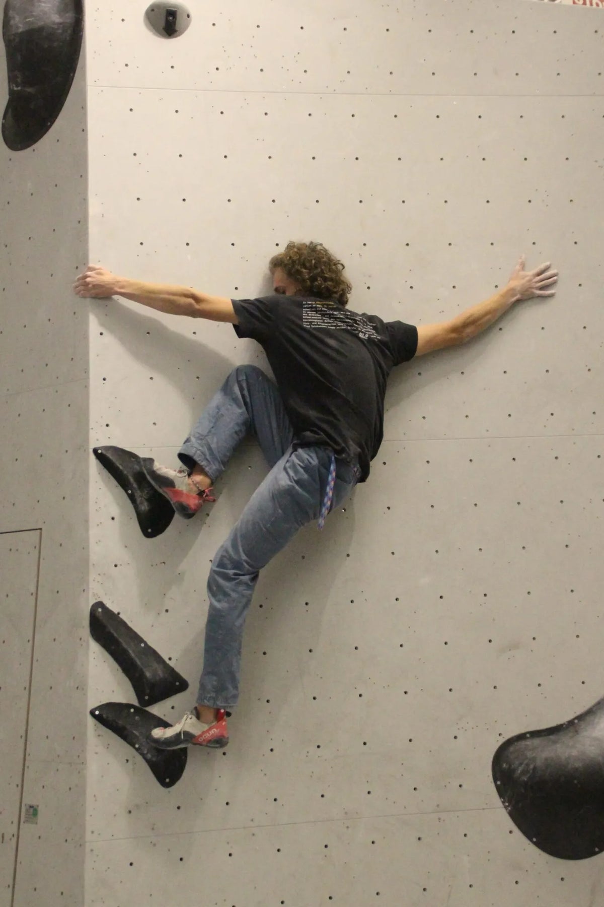 Mann beim Klettern an der Boulderwand im Sportpoint Meckenheim – konzentrierte Körperhaltung auf strukturierter Wand