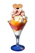 Bunter Eisbecher mit gemischtem Fruchteis, frischen Früchten, Sahne und Erdbeersoße