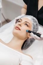 Frau mit Haarnetz erhält eine Aquafacial-Behandlung mit einem speziellen Gerät zur tiefenwirksamen Hautreinigung