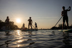 Gruppe von Menschen beim Stand-Up-Paddling auf der Spree im Sonnenuntergang