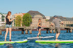 Zwei Personen beim Stand-Up-Paddling auf der Spree mit Blick auf historische Gebäude