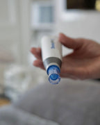 Hand hält einen Dermapen zur kosmetischen Hautbehandlung