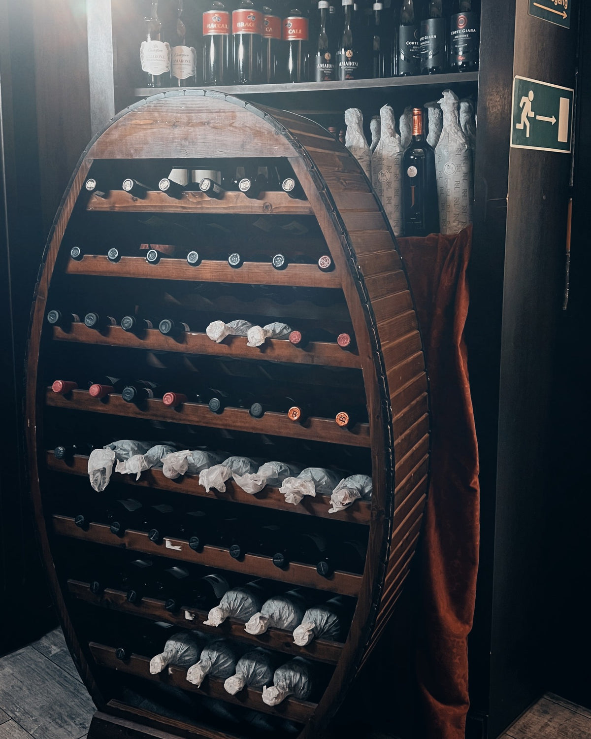 Rustikales Weinregal in Fassform mit edlen Weinen in der Alten Kanzlei Frankfurt