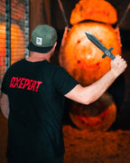 Mann mit schwarzem „AXEPERT“-Shirt beim Messerwerfen in Weiterstadt vor Zielscheibe aus Holz
