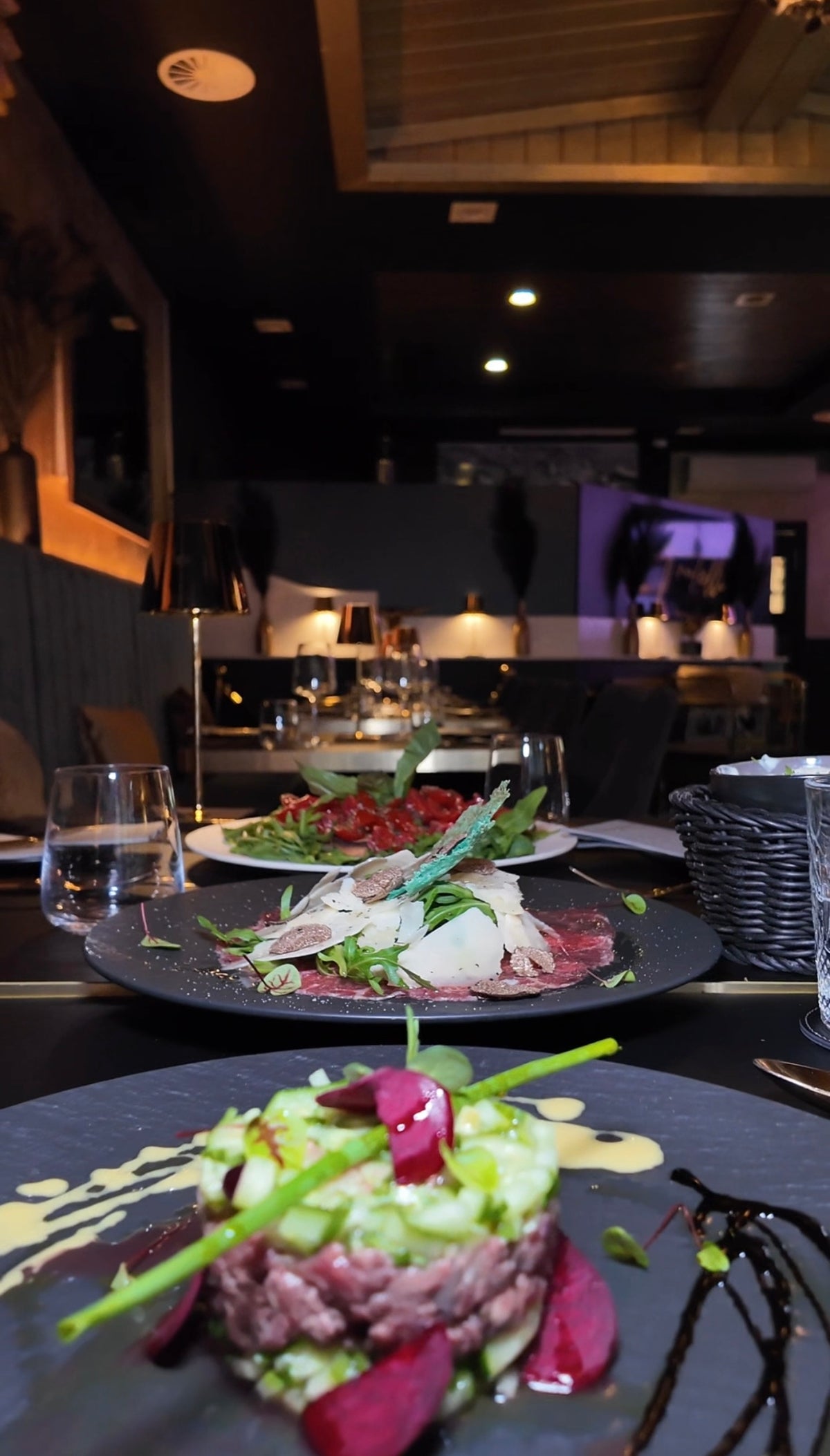 Elegant angerichtete italienische Hauptspeisen auf schwarzen Tellern im stilvollen Ambiente des Ristorante Fratelli Bottrop.