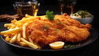 Knuspriges Schnitzel mit Pommes, Zitronenscheibe und Petersilie auf einem Teller serviert