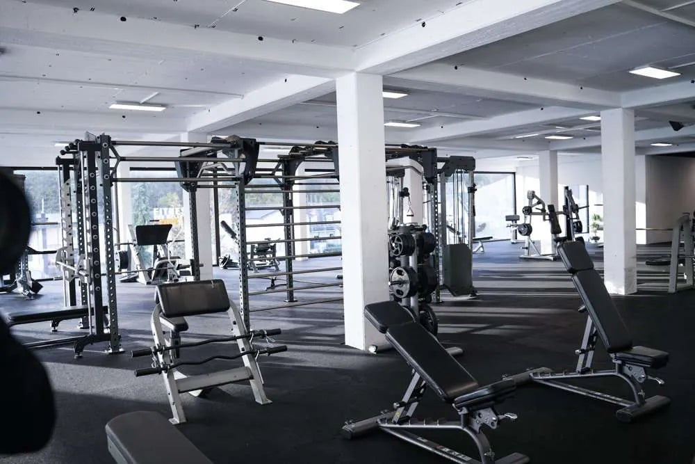 Großzügiger Krafttrainingsbereich mit Hantelbänken und Fitnessstationen im Fitness Wellness Loft Schleiden