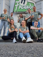 Team der 11 Freunde Bar Essen vor dem Eingang mit Bier in der Hand
