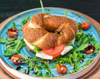 Frisch belegter Simit mit Käse, Tomaten und Rucola auf dekorativem Frühstücksteller bei Meeting Die Brunchery Dortmund
