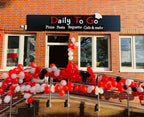 Feierlich geschmückter Eingang der Pizzaria Daily To Go in Düsseldorf mit roten und weißen Ballons