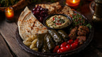 Dunkel angerichtete Mezzeplatte mit Weinblättern, Hummus, Brot, Trauben und Tabbouleh